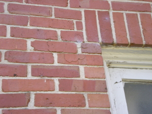 Example of early signs of stress corrosion in lintel causing brick fissures and future spall.