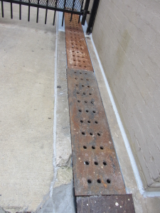 Example of urban trench drain to carry run-off to street curb.